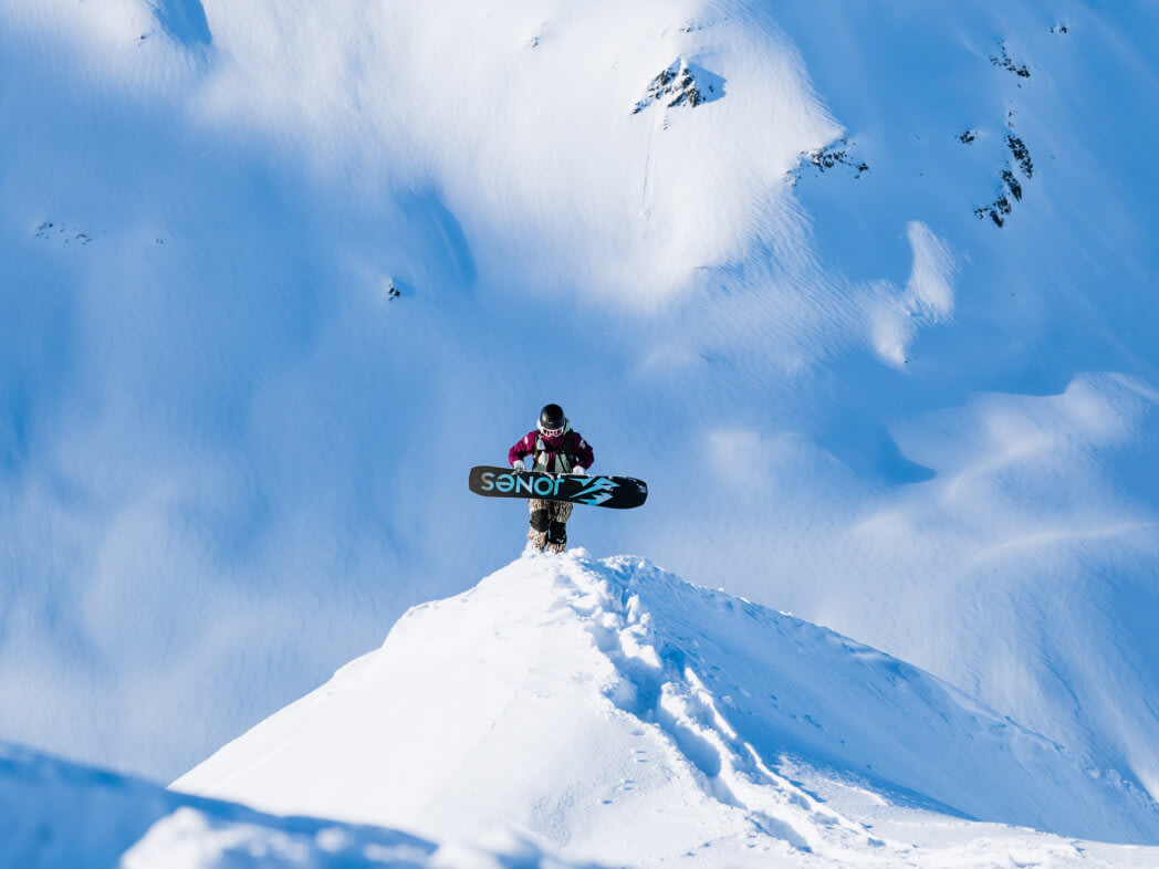 Snowboarder at the top of a peak